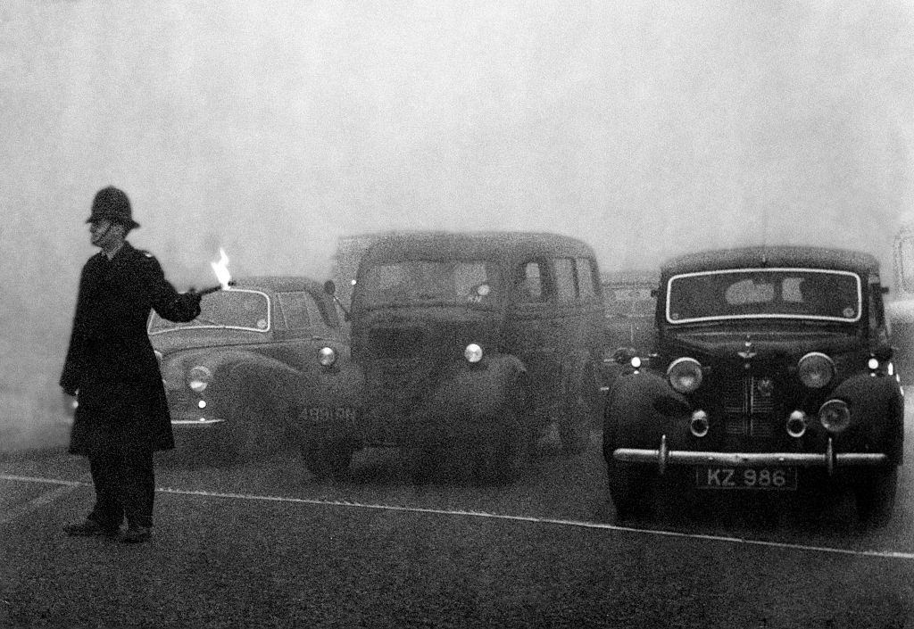 #24 Policeman on point duty using flares to guide the traffic during a heavy smog in London. 8th December 1952