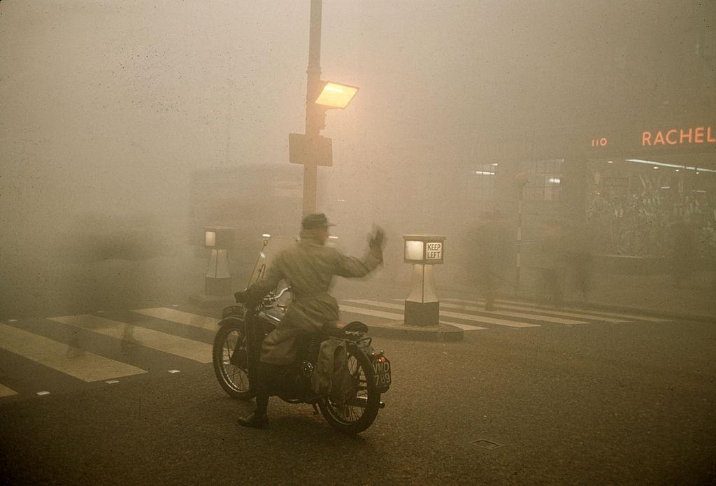 #5 On a foggy night, a man on a motorcycle waits at a pedestrian cross-walk, London, 1952.