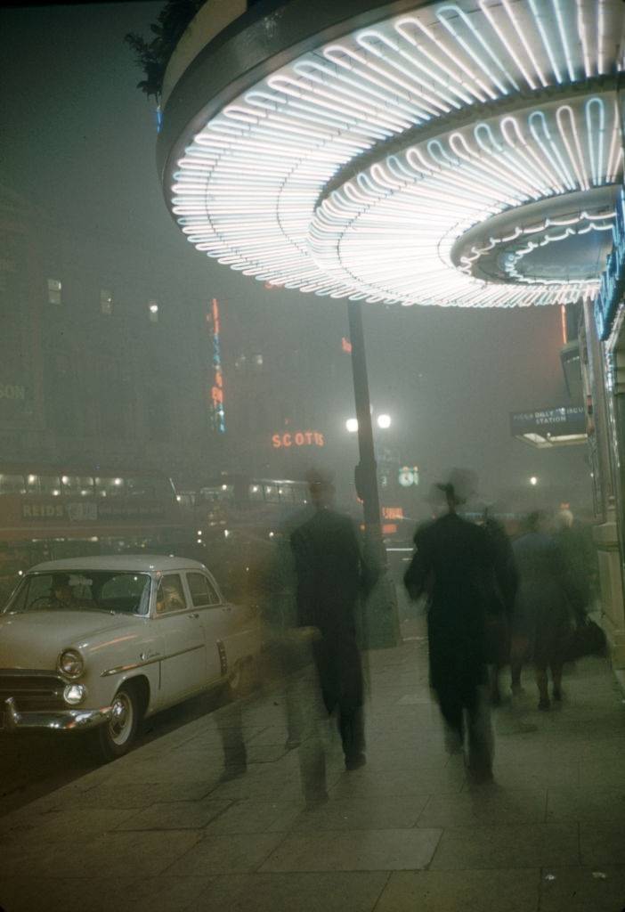 #9 Street scene on a foggy night under the marquee of the Criterion Theatre in Piccadilly Circus, London, 1952.