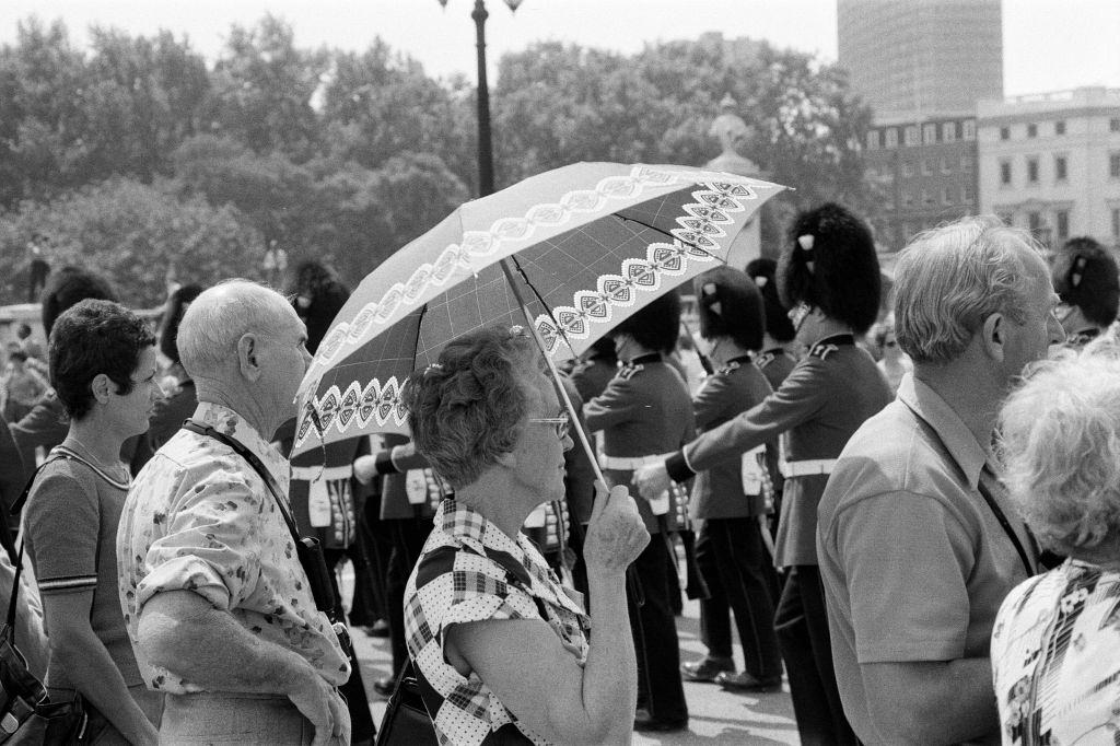 #33 Changing of the Guard in London today. An umbrella serves as a sun-shade for a spectator, 8th June 1976.