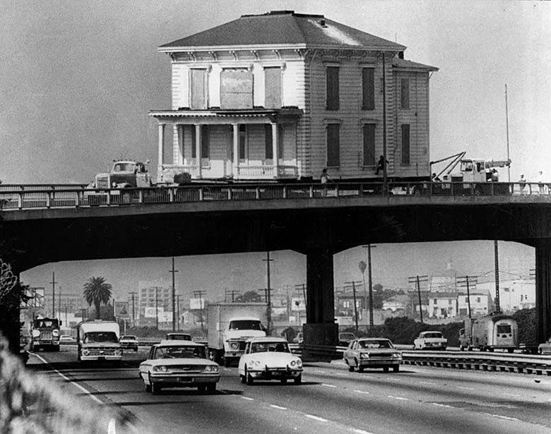 #3 An early 1900s house crossing over the Nimitz Freeway in Oakland stops so workers can free its eaves from being entangled with a light pole. Oct. 22, 1973