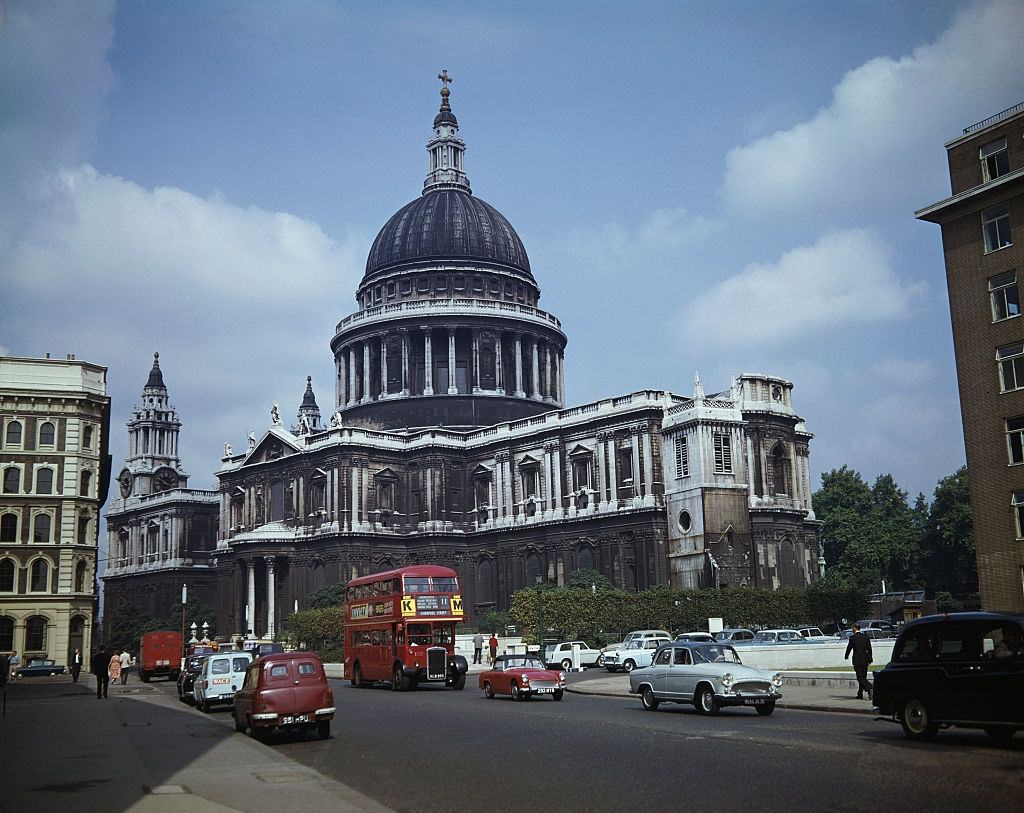 #1 St Paul’s Cathedral in London with cars and a bus passing through St Paul’s churchyard and along Cannon Street, 1962.