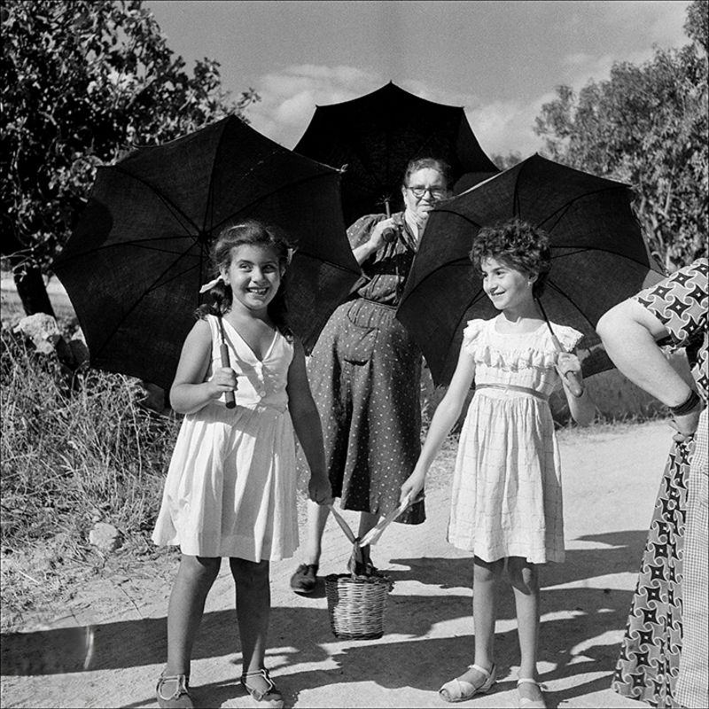 #13 Two dolls and a woman walking with umbrellas, 1956