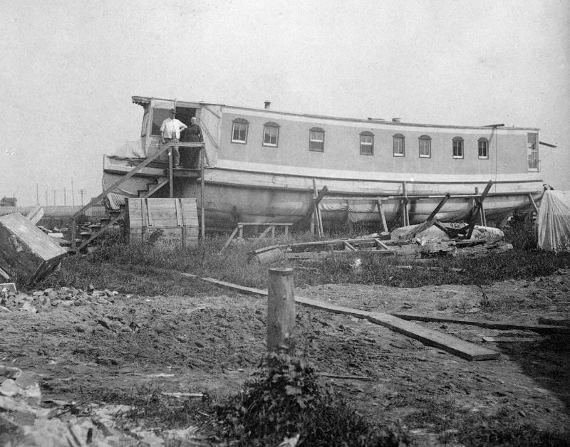#1 Man and woman standing at the entrance to their house, built out of the hull of a ship; an ark, circa 1900