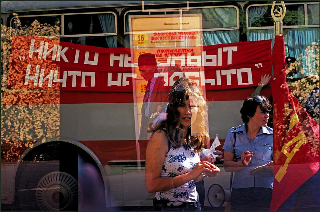 #4 A woman looks through a cafe window whilst bus tour guide checks names.