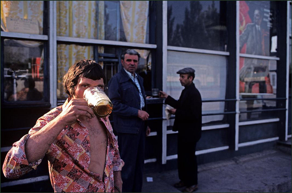 #37 Men buying beer from a kiosk to drink on the street in the city.