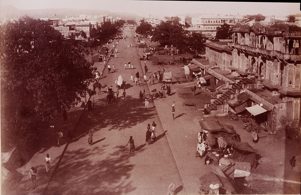 #40 People and a camel on a wide street in a city in Ceylon, ca. 1880s.