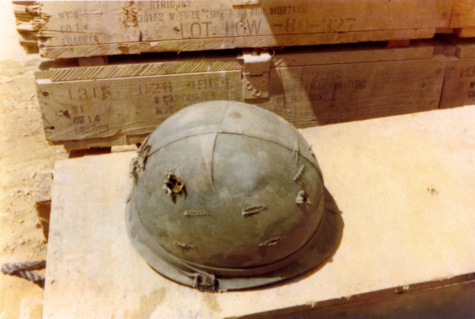 #12 The photographer’s helmet, with two bullet holes. Fire Base L.Z. Stinson, Quang Ngai Province, Vietnam.