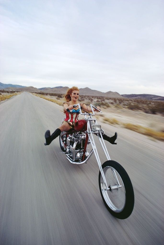 #27 Ann-Margret rides a chopper motorcycle in the desert outside Las Vega, 1969.