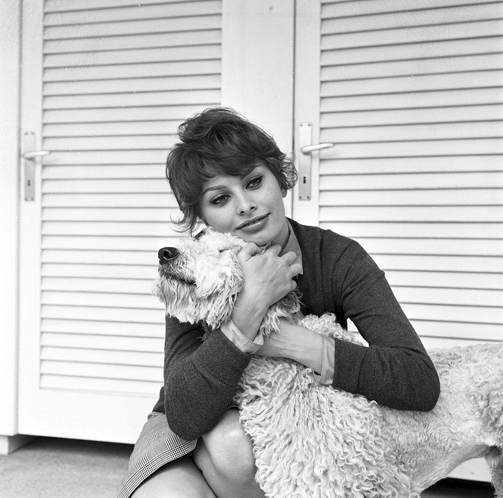 #72 Sophia Loren hugging her dog during a photo shoot in her villa in Burgenstock, 1950s.
