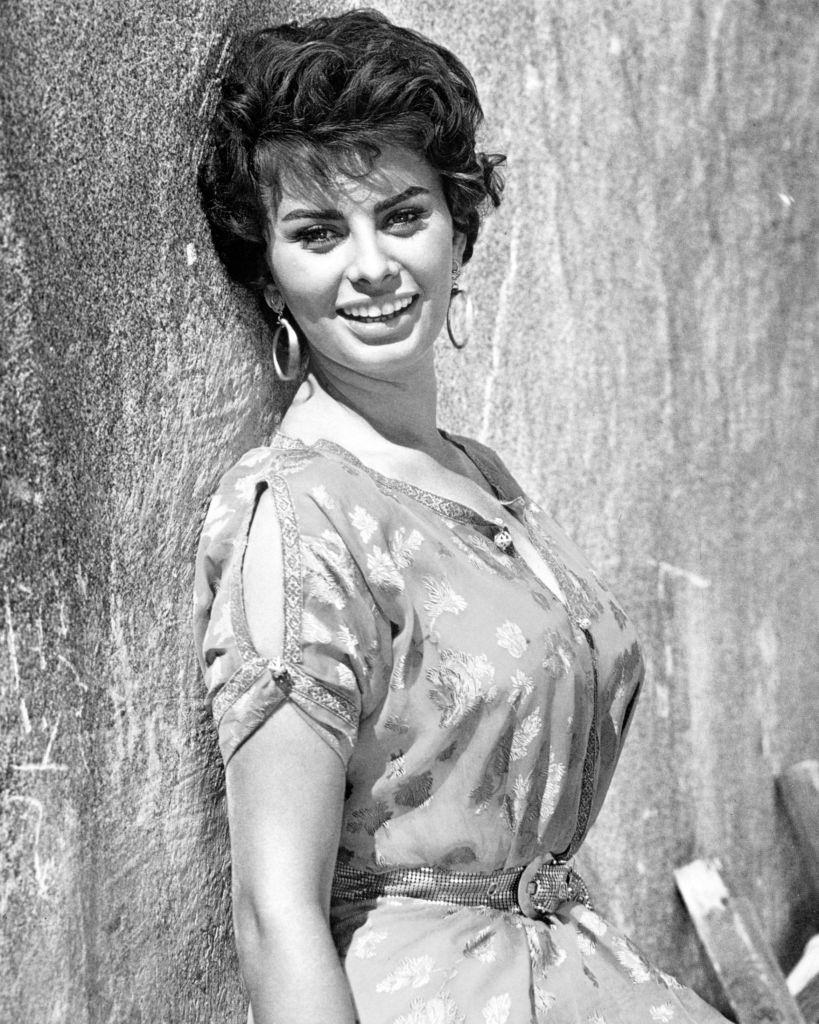 #8 Sophia Loren posing against a wall, wearing a short-sleeve print pattern dress, 1950s.