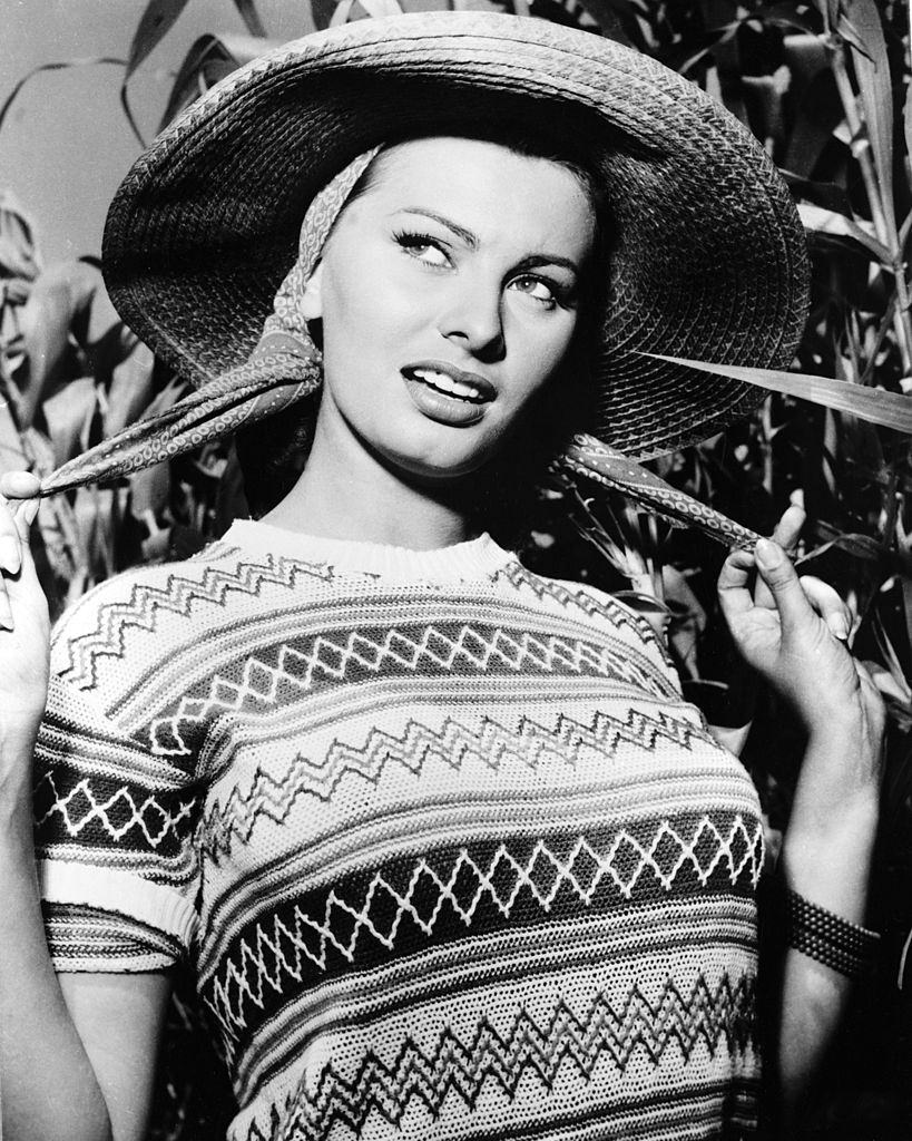 #9 Sophia Loren in a short-sleeve jumper and a wide-brim straw hat, circa 1950.