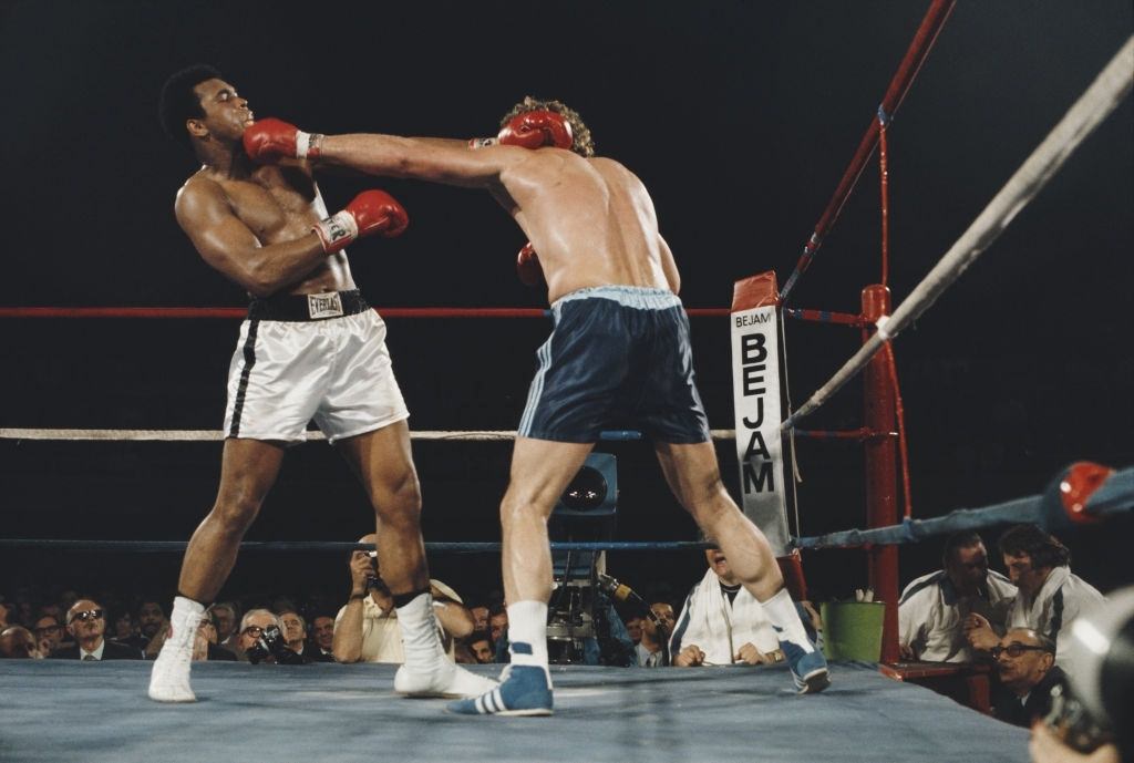 #64 Muhammad Ali fighting against British boxer Joe Bugner during their heavyweight fight at Las Vegas Convention Centre, 1973.