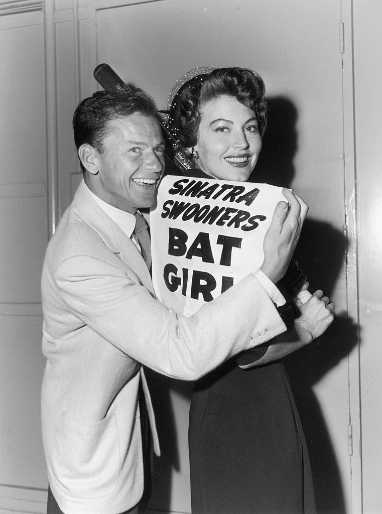 #8 Frank Sinatra and Ava pose with a sign that reads, ‘Sinatra Swooners Bat Girl,’ July 12, 1949.