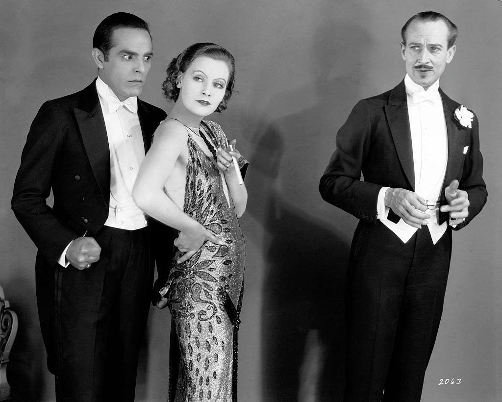 #67 Greta Garbo with actor Antonio Moreno and HB Warner on the set of “The Temptress”, 1924.