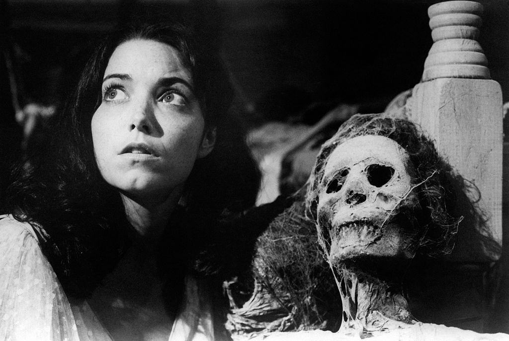 #31 Karen Allen beside a human skeleton in the film Raiders of the Lost Ark. 1981.