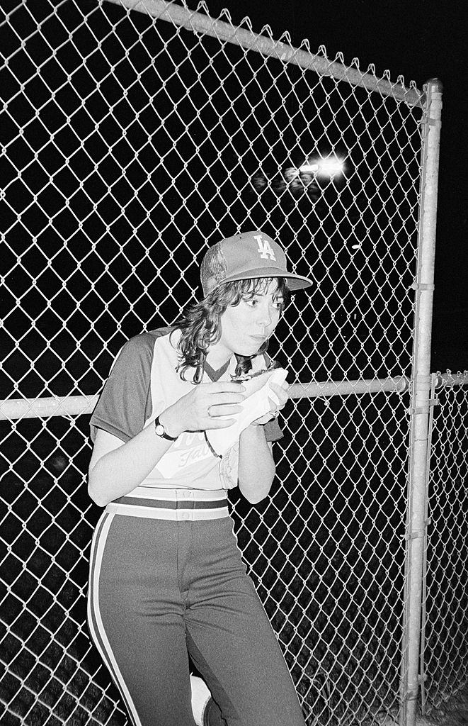 #9 Mackenzie Phillips enjoying a hot dog during a game, 1980.