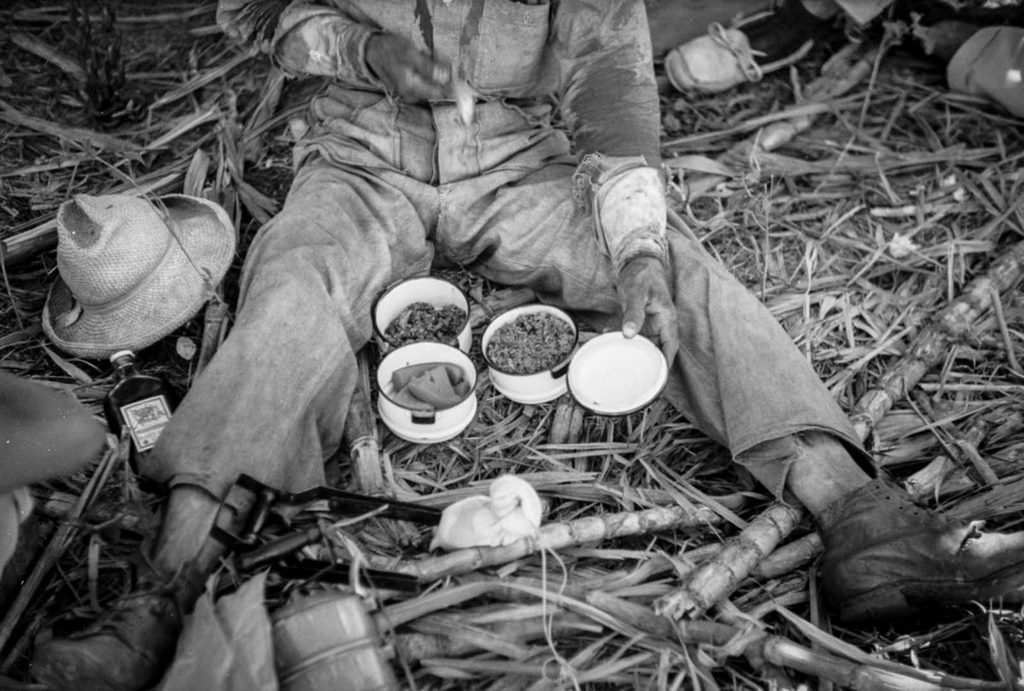 #7 A worker on a sugar plantation pauses for a lunch of rice, beans, and papaya.