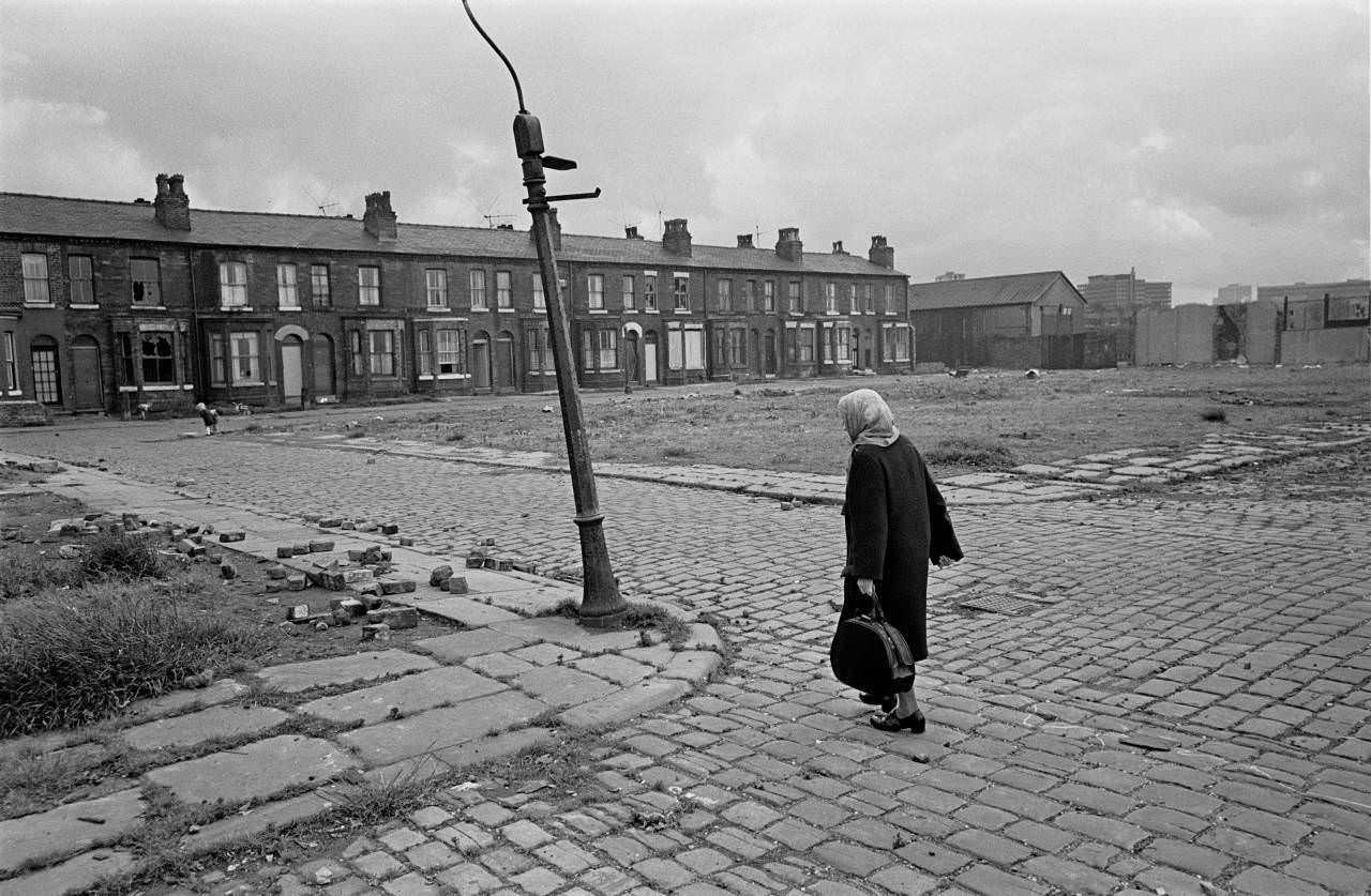 #11 Pensioner crossing derelict land towards her home, Salford 1971