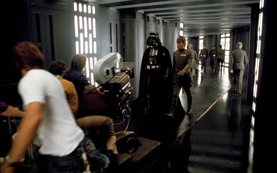 A classic walk’n’talk shot, decades before The West Wing made it a cliche.