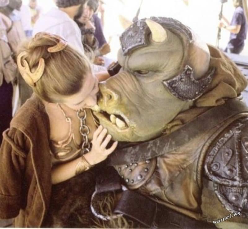 Carrie Fisher poses with a Gamorrean guard, one of Jabba the Hutt’s lackeys, on the set of Return Of The Jedi.