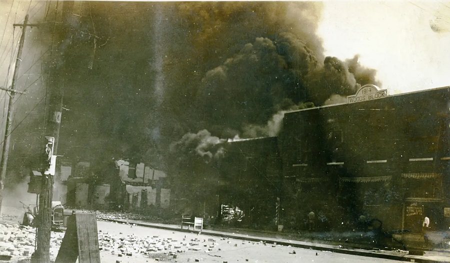 #2 Clouds of black smoke rise over the rubble of buildings destroyed in the Tulsa massacre in June 1921.