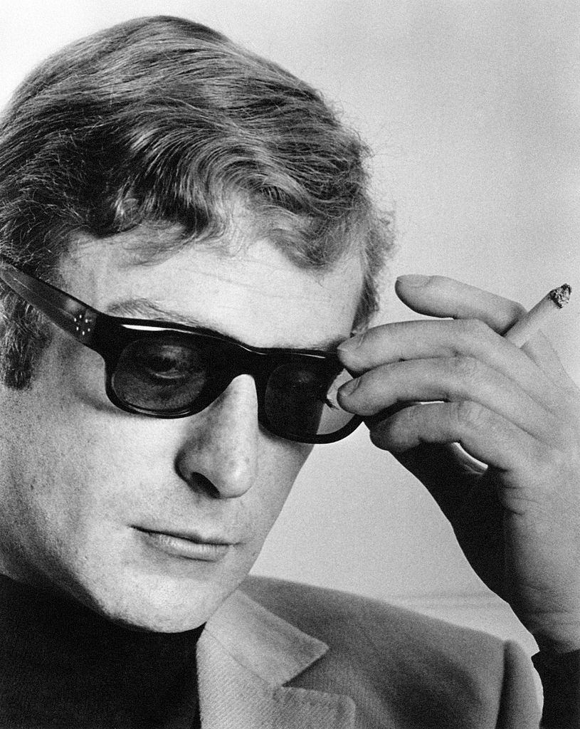 #18 Micheal Caine with a cigarette in his hand during an interview, 1964.