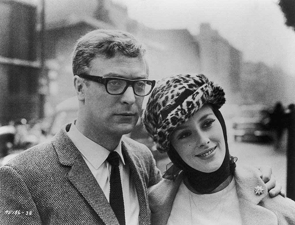 #27 Michael Caine poses with his co-star Sue Lloyd during a break in the location filming of ‘The Ipcress File’ in London, 1965.