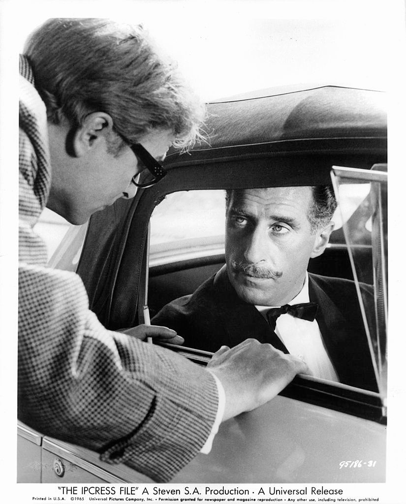 #30 Michael Caine talking with Nigel Green, 1965.