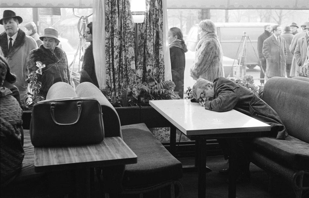 #31 Michael Caine asleep in a cafe with his head resting on the table, 1965.