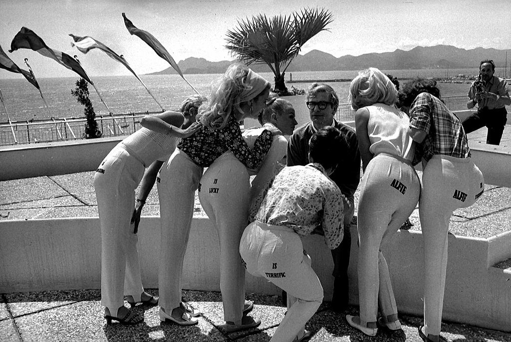 #63 Michael Caine with models for the promotion of his film “Alfie”, 1966.