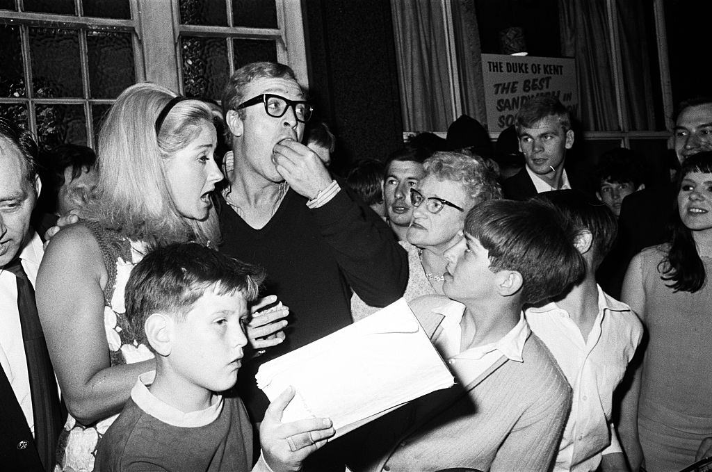 #52 Michael Cain with Lynda Bird Johnson, daughter of the US President, at a party in a pub, 1967.