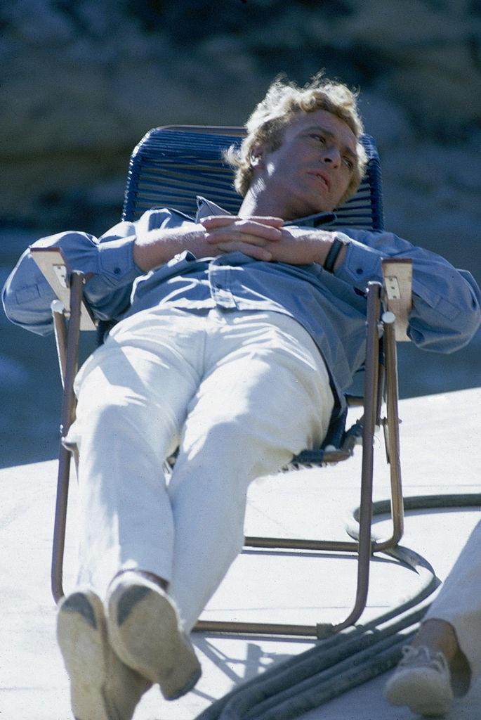 #53 Michael Caine relaxes on the European set of ‘The Magus’, 1968