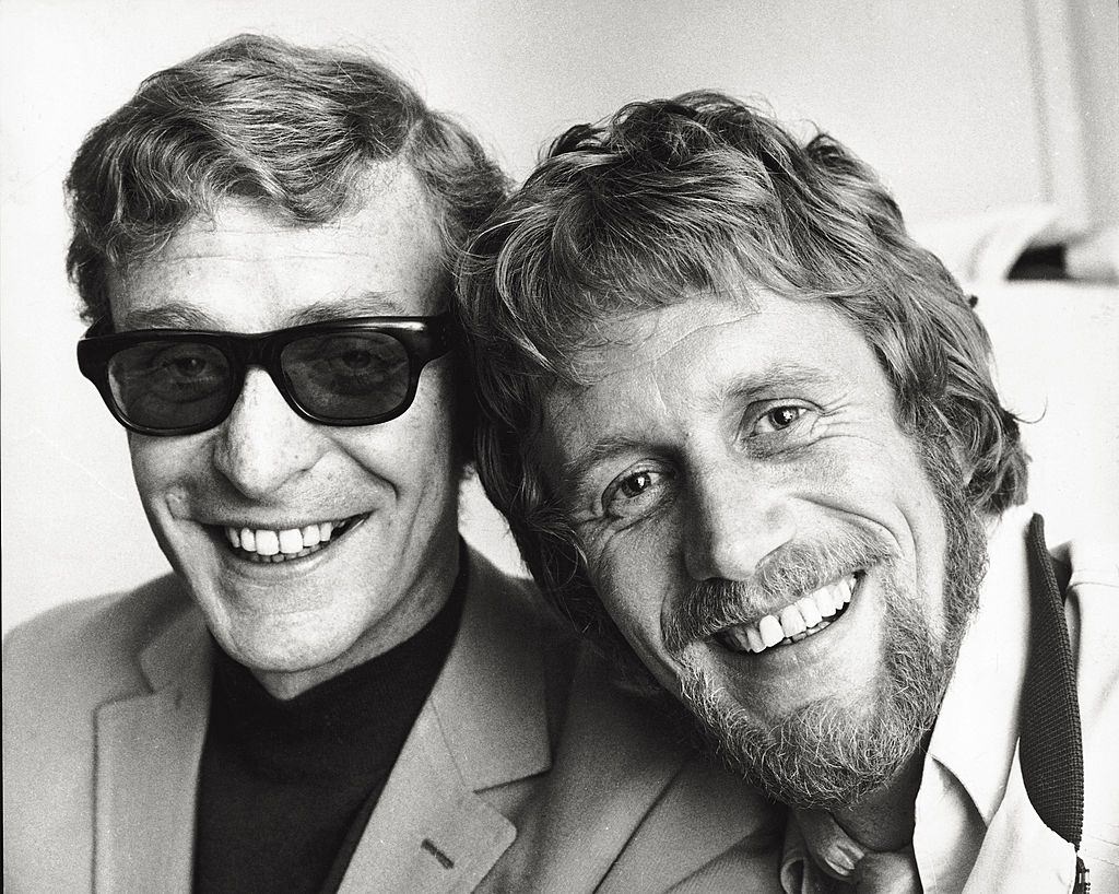 #56 Michale Caine with British director Peter Collinson smiling, during filming on ‘The American Job’, 1968.