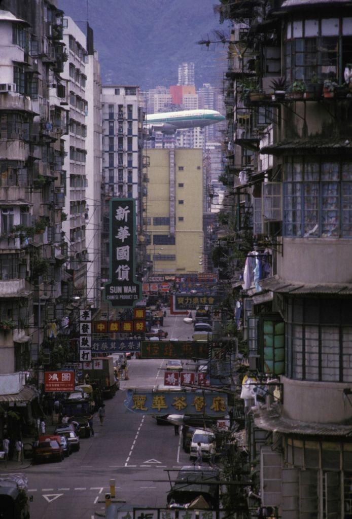 #1 A plane flying very close to the tops of buildings before landing at Kai Tak airport in Hong Kong, circa 1980