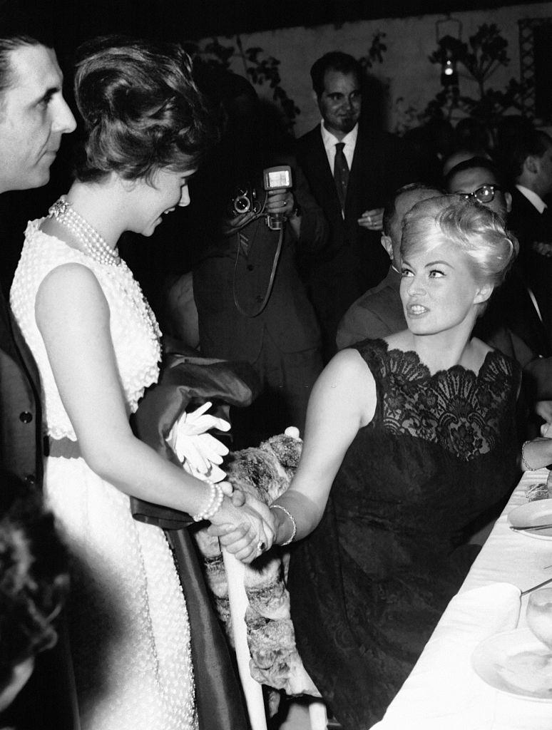 #67 Gina Lollobrigida saying hello to Anita Ekberg at a gala diner on July 6, 1961 in Rome, Italy.