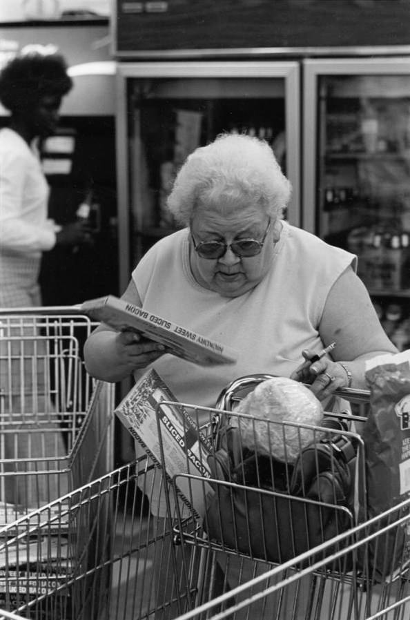 #13 Woman putting bacon in grocery cart, 1980