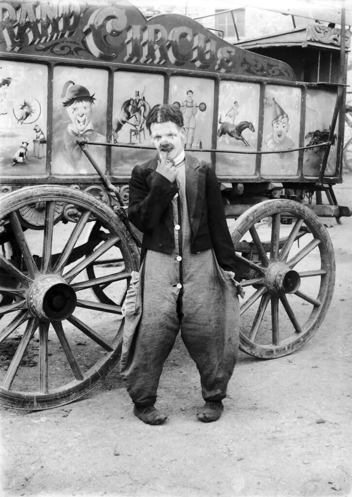 #19 A clown beside a wagon of The Grand Circus, 1910.
