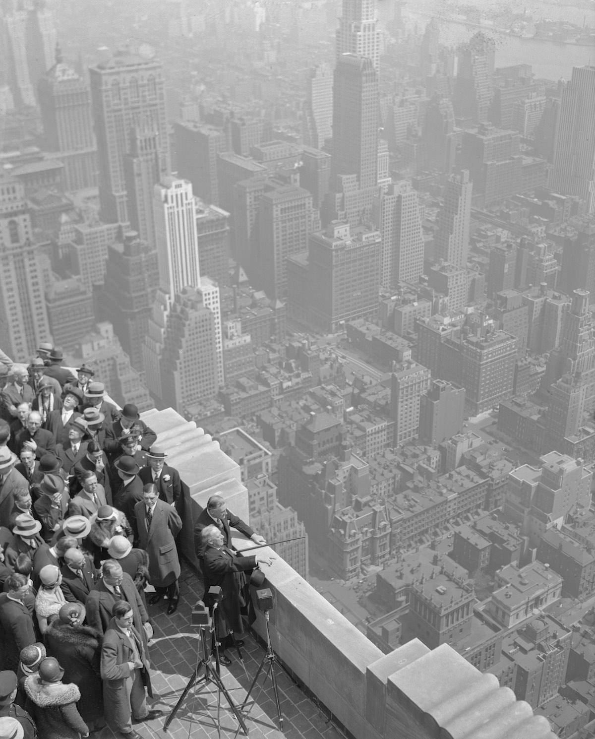 #16 Ex-Governor Alfred E. Smith, Governor Franklin D. Roosevelt, and others at the top of the Empire State Building, tallest in the world, gazing out over the New York panorama.