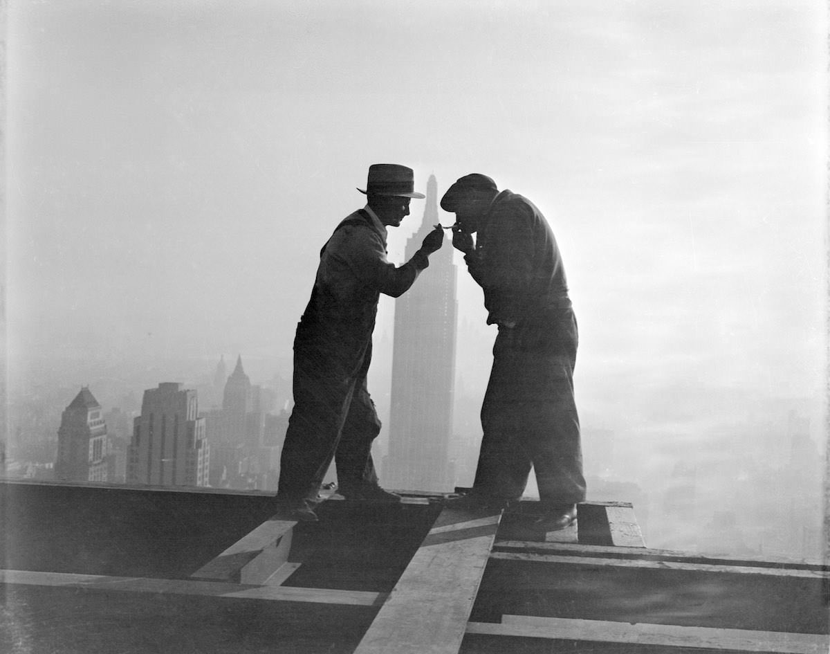 #8 New York City: Lighting Up ‘Way Up.’ A striking silhouette atop the gigantic RCA Building in Rockefeller Center, New York, as workmen light their cigarettes at the end of a working day.
