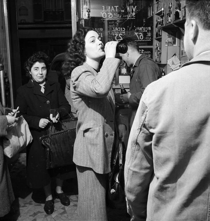 #5 A young woman drinks a bottle of Coca-Cola in a Paris shop.