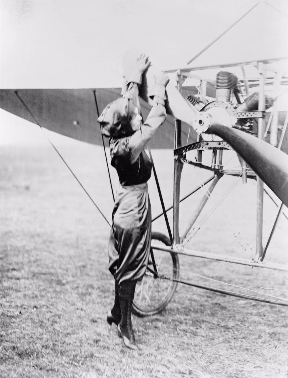 #13 Harriet Quimby, wearing her purple satin flying suit, pulls the Chauvière Intégrale propeller of the Blériot XI to start the air-cooled Anzani W3 (“fan” or “semi-radial”) three-cylinder engine.