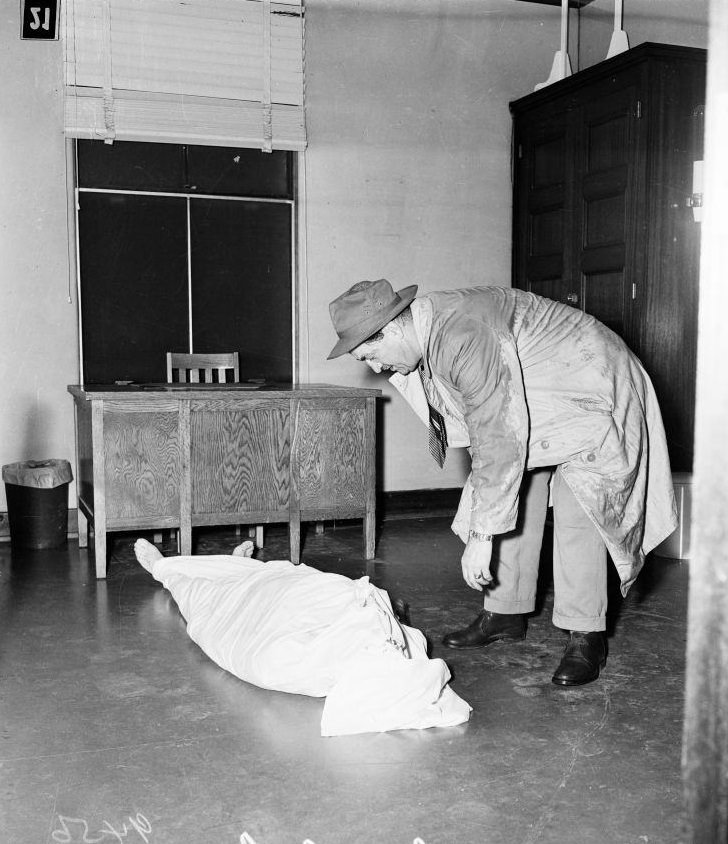 #19 Detective Danny Shea, looking over body at Van Nuys Receiving Hospital. 18 January 1952.