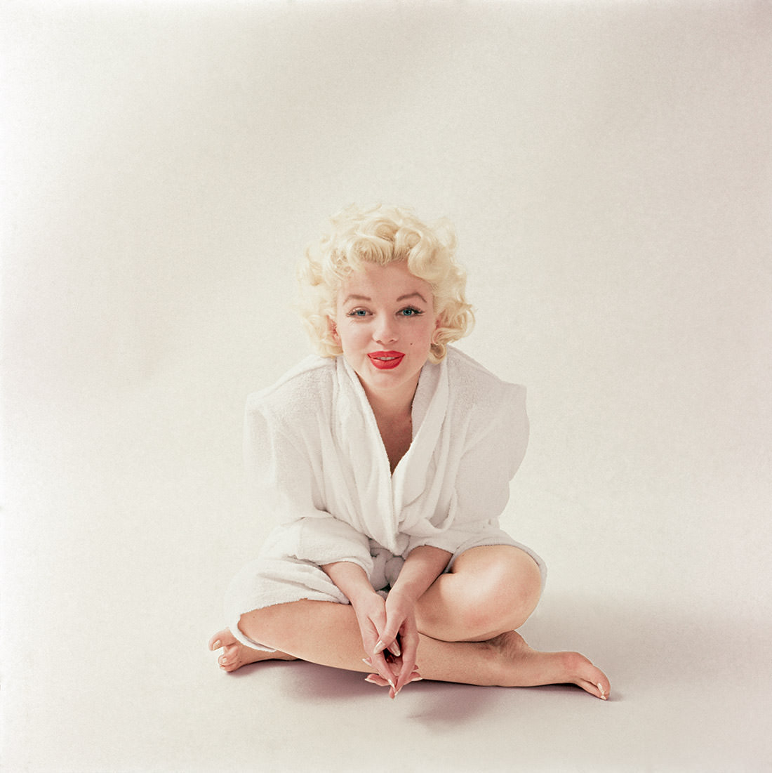 #5 Monroe wears her favorite outfit, a white terrycloth robe, just after finishing her makeup in March 1955.