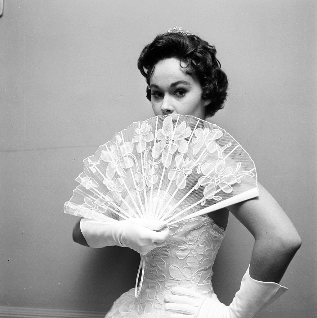 #15 Marla English holding a wing during a fashion photoshoot, 1956.