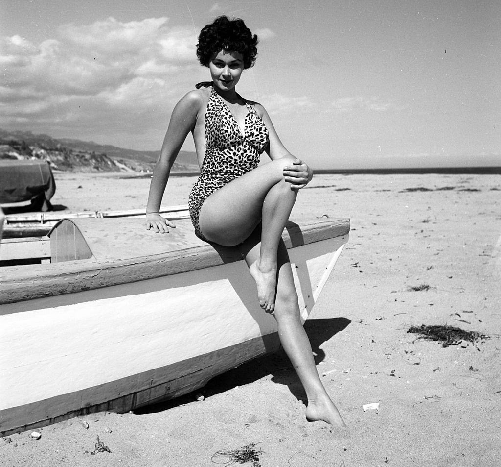 #21 Marla English poseing with a boat at the beach, 1954.
