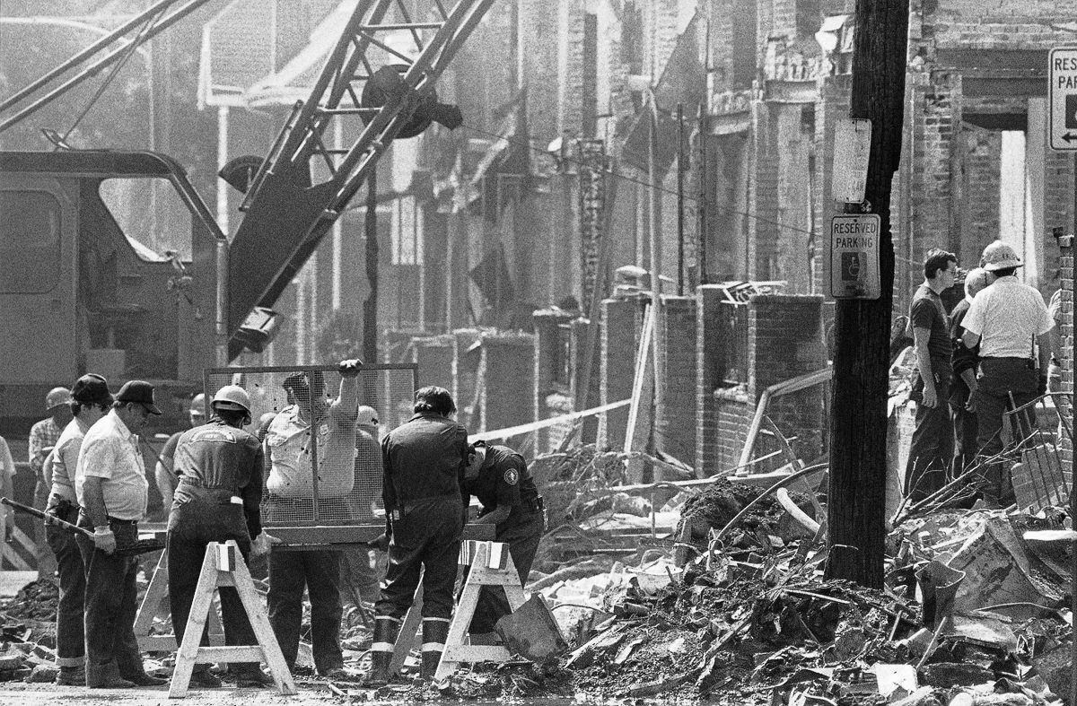 #18 Investigators use a screen to sift through debris. May 16, 1985