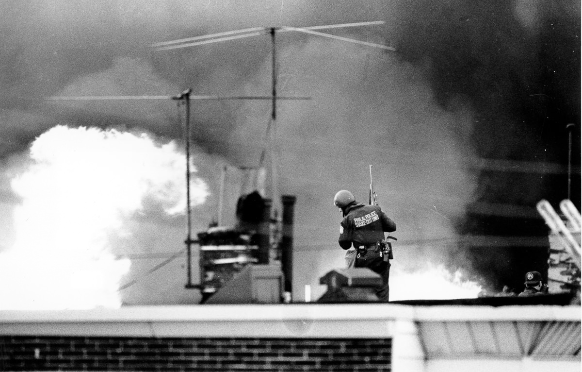 #10 A police officer looks on as the blaze spreads. May 13, 1985