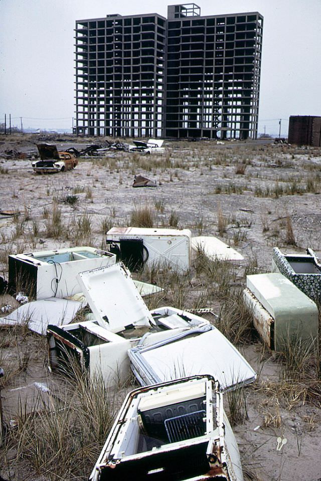 #24 Skeleton of apartment building never completed, abandoned refrigerators and a burned out 1965 Ford Mustang, Breezy Point, Queens looking toward Brooklyn, 1973