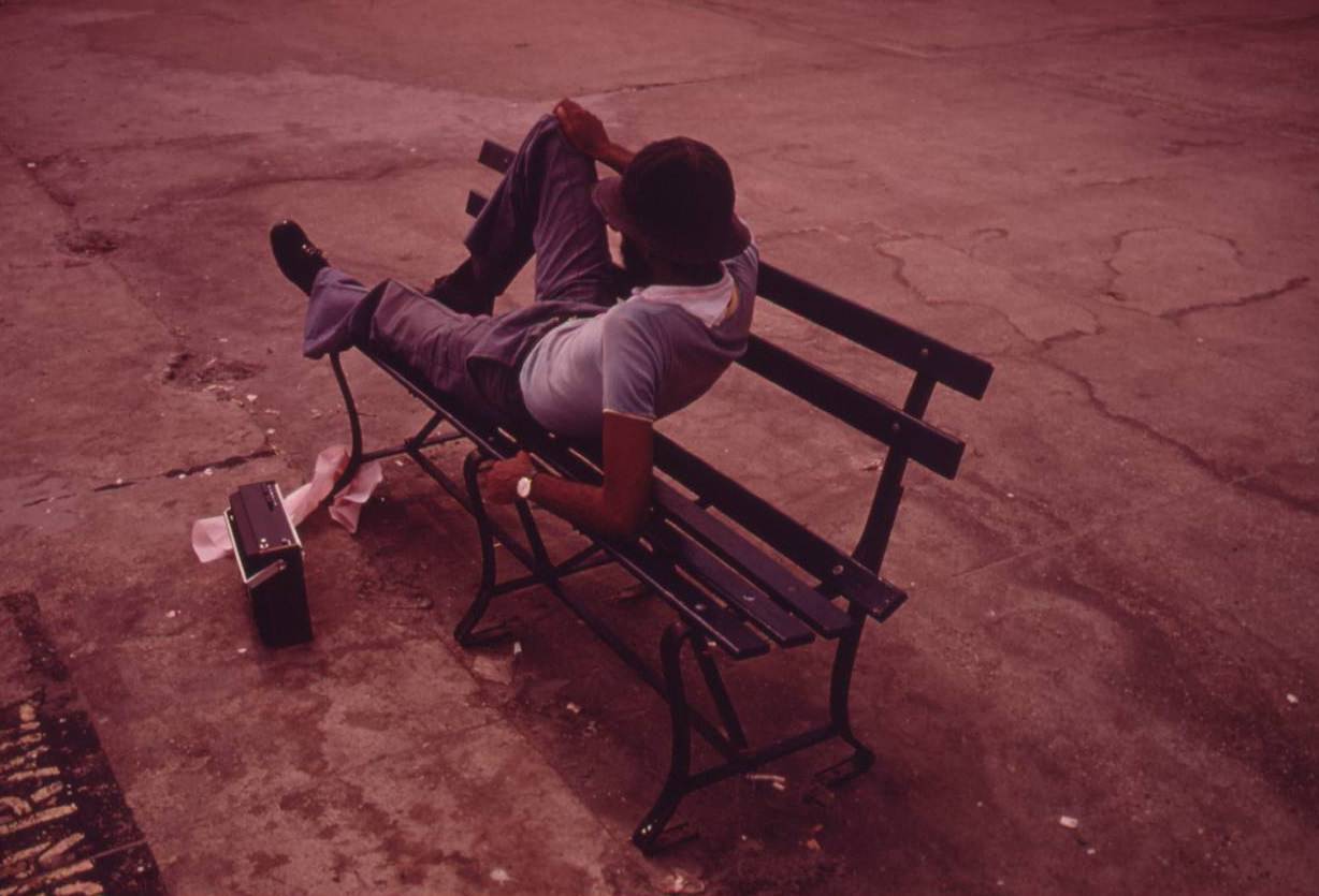 #41 Man lounging on a park bench with his radio on the Reis Park boardwalk in NYC, July 1974.